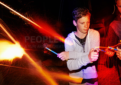 Buy stock photo Night, celebration and teenager with fireworks, friends and party for New Year, fourth of July or birthday. Festival, lights and boy at outdoor social event with flare, student and sparkle with flame