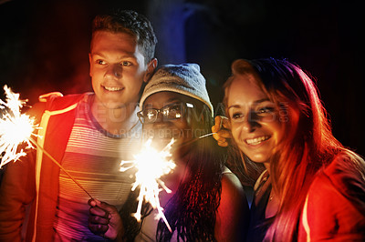 Buy stock photo Cropped shot of a group of teens playing with fireworks