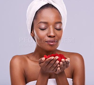 Buy stock photo Towel, skincare and black woman with red petals, beauty and dermatology on a white studio background. Happy, African person and model with natural cosmetics and grooming with treatment and luxury