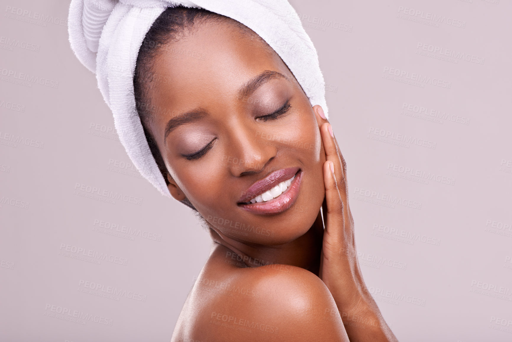 Buy stock photo Hair towel, beauty or happy black woman in studio for skincare, wellness or body care on purple background. Dermatology, cleaning or hands on face of African female model with cosmetic, shine or glow