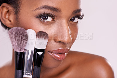 Buy stock photo Skincare, makeup brushes and portrait of black woman with brush on face in studio with cosmetic application tool. Skin care, blush and cosmetics, beauty model with luxury powder on pink background.