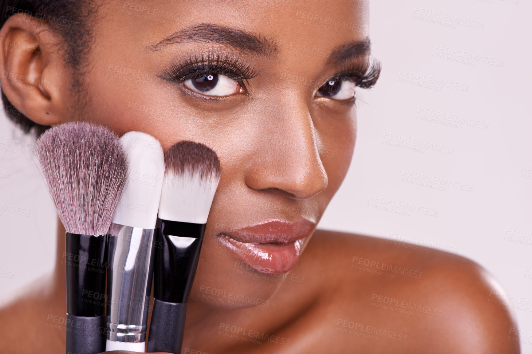 Buy stock photo Skincare, makeup brushes and portrait of black woman with brush on face in studio with cosmetic application tool. Skin care, blush and cosmetics, beauty model with luxury powder on pink background.