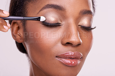 Buy stock photo Black woman, face and brush for eyeshadow with makeup, beauty and lashes isolated on pink background. Skin glow, cosmetics product and tools for cosmetology, shimmer or glitter with shine in studio