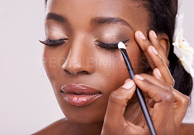 Buy stock photo Black woman, face and brush for eyeshadow with beauty, makeup and lashes on grey background. Skin glow, hands and apply cosmetic product with tools for cosmetology, shimmer or glitter with shine