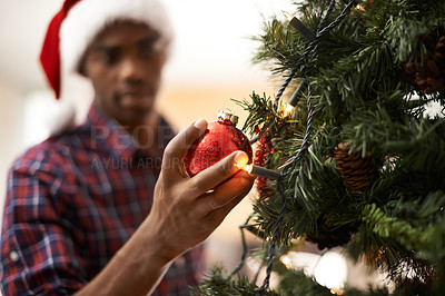 Buy stock photo Shot of a handsome young man decorating a christmas tree