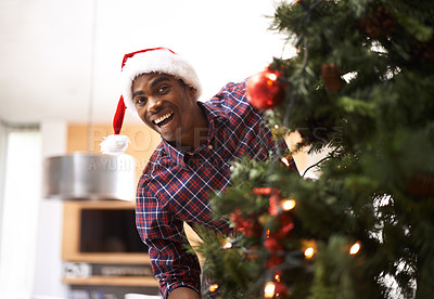 Buy stock photo Portrait, energy and black man with Christmas tree in living room of home for decoration or holiday. Smile, celebration in December and happy young person in apartment with Santa hat for tradition