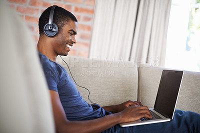 Buy stock photo Man, online and music with laptop on sofa for movie streaming, podcast and internet games with listening. Happy, black person and technology with headphones for relax, studying and learning in lounge
