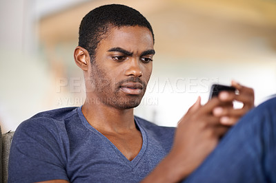 Buy stock photo Man, face and smartphone on sofa with relax for internet streaming, communication or online games in home. Student, african person and phone or technology in living room for research, chat or serious