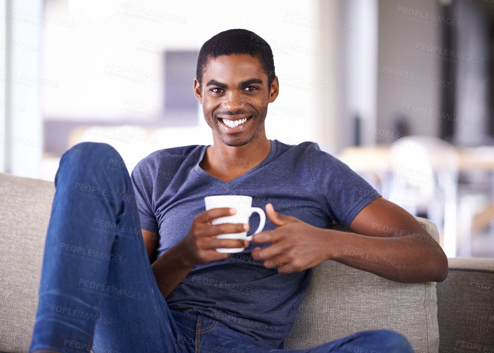 Buy stock photo Cropped shot of a handsome young man relaxing with a cup of coffee