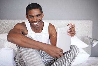 Buy stock photo Black man, portrait and bed with tablet for social media, communication or online entertainment at home. African male person with smile for technology, networking or browsing in bedroom at the house