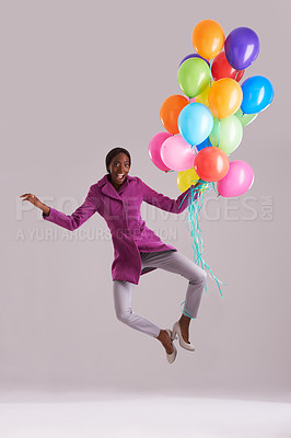 Buy stock photo Balloon, jump and portrait of happy black woman in studio for birthday, celebration and present. Fashion, excited and isolated person with inflatable for party, gift and surprise on gray background