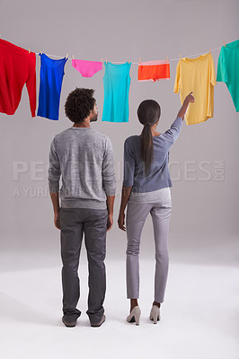 Buy stock photo Laundry, choice and clothing of couple with back view in studio for hygiene, housework, washing in white background. Domestic, black man and woman for household task, clean or fresh fabric on line