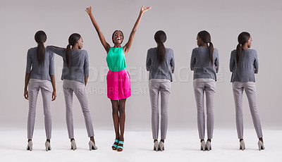 Buy stock photo Studio shot of a woman in a colorful outfit standing out from the crowd
