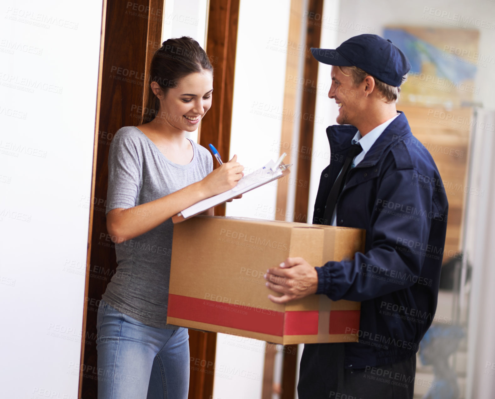 Buy stock photo Shot of a courier making a delivery to a smiling customer