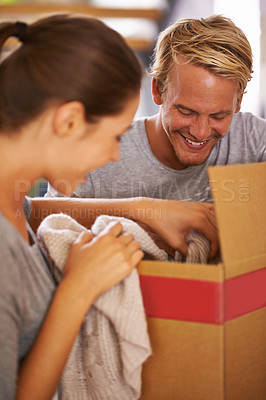 Buy stock photo Couple, moving and packing clothes in box and excited for new house and preparing for property. People, unboxing and happy to rent real estate, apartment and start of marriage in home together