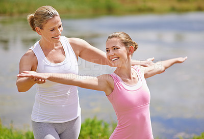 Buy stock photo Shot of a young woman being instructed in an outdoor yoga class