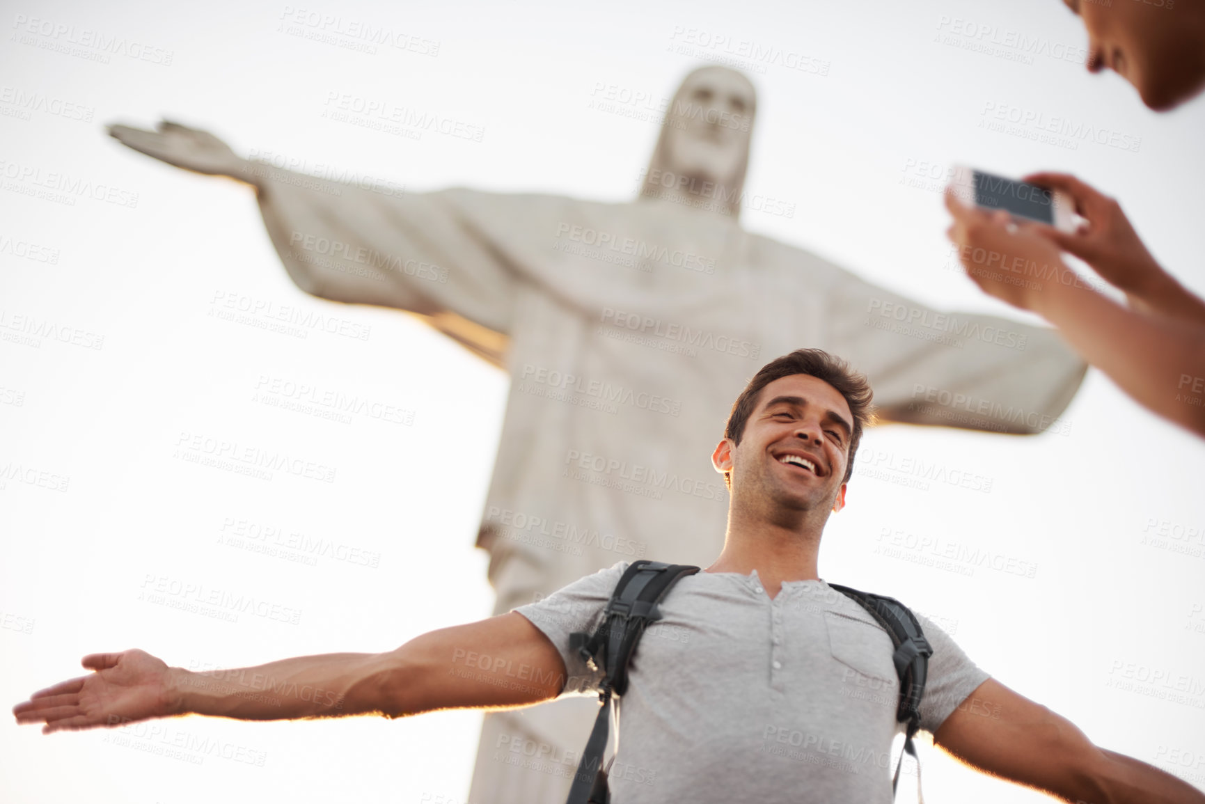 Buy stock photo Man, photo and travel by christ the redeemer, crucify and happy in christian culture on vacation. Jesus sculpture, rio or guy for social media update in mobile picture, peace or tourism in brazil