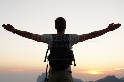 Buy stock photo Silhouette shot of a young man standing against the sky