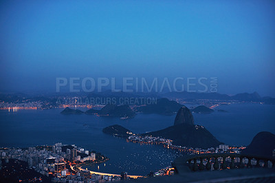 Buy stock photo Aerial, night and city skyline by ocean, mountains and landscape view of urban buildings with lights. Drone, cityscape or coastline in rio brazil for holiday, tourism and travel destination by sea