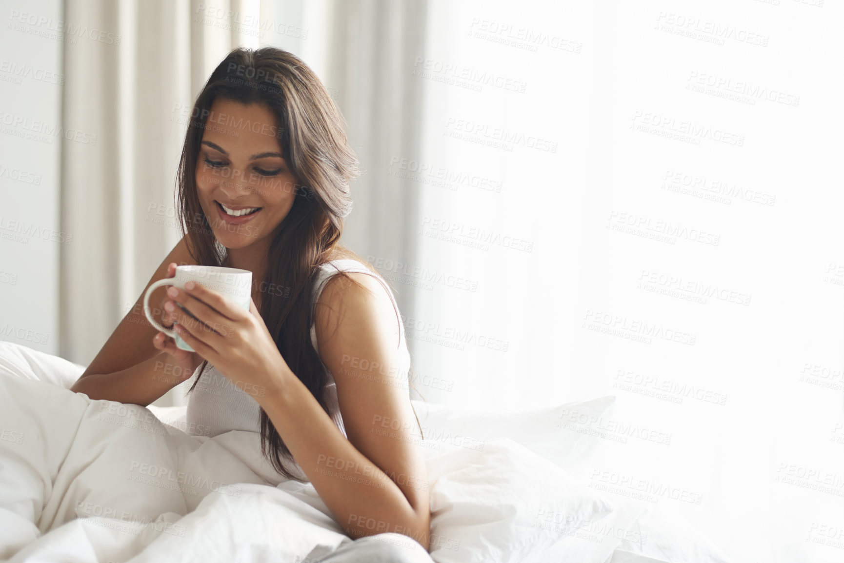 Buy stock photo Happy, calm and woman with coffee in bedroom with caffeine to wake up in morning at home. Smile, relax and comfy young female person drinking mug of cappuccino, espresso or latte in apartment.