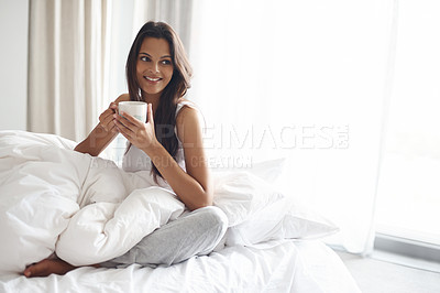 Buy stock photo Shot of a beautiful young woman enjoying a cup of coffee in bed