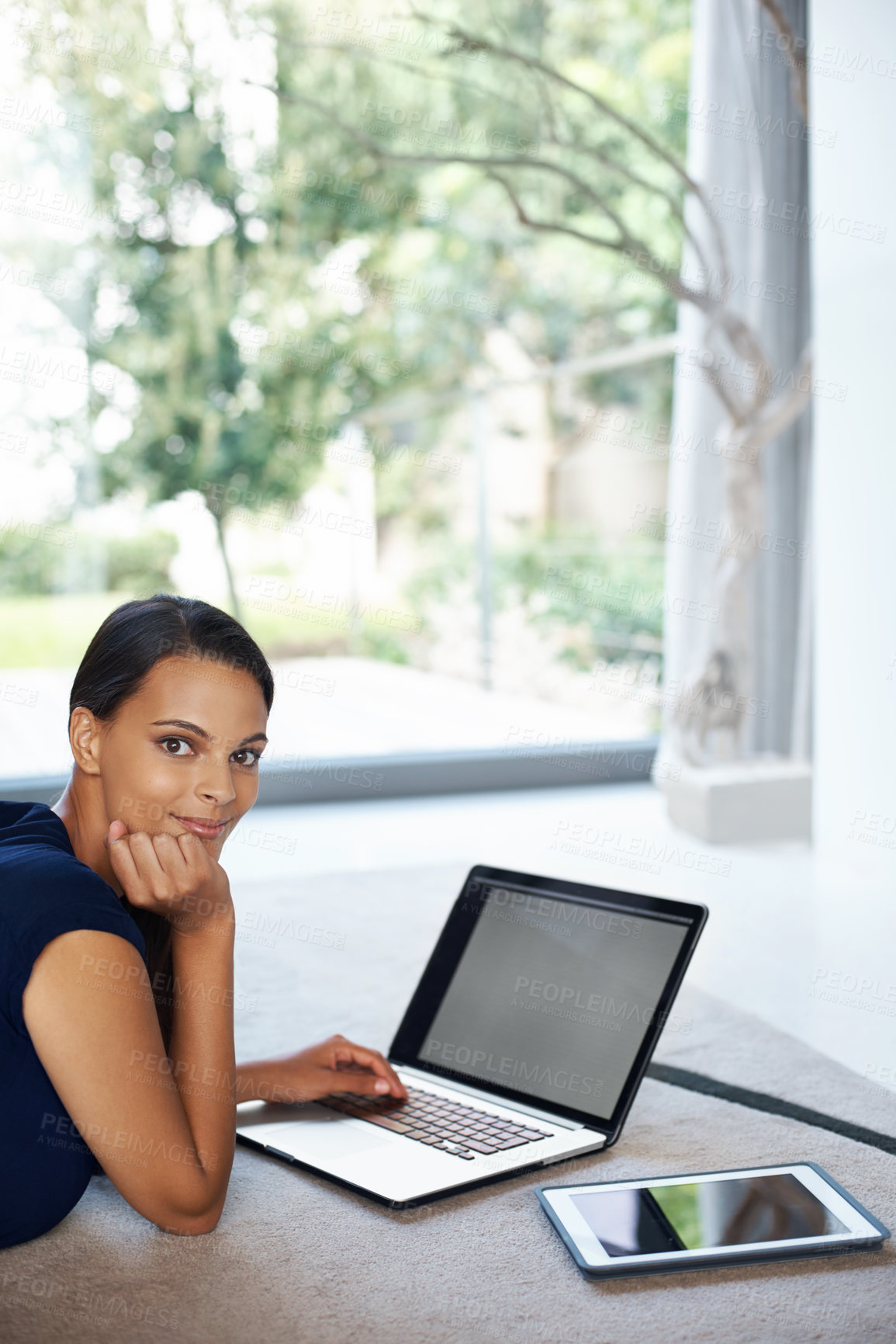 Buy stock photo Computer, smile and portrait of woman relaxing on carpet working on freelance project at home. Happy, technology and female person with laptop for creative research laying on floor mat in living room