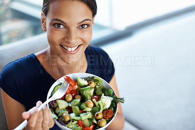 Buy stock photo Top view of a beautiful young woman enjoying a healthy salad in her home