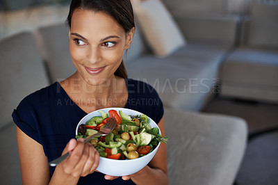 Buy stock photo Top view of a beautiful young woman enjoying a healthy salad in her home