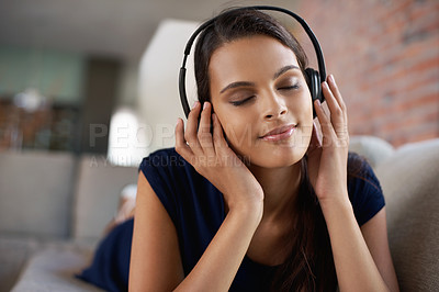Buy stock photo Face, music and relax with woman on sofa in living room of home to smile for free time break. Headphones, peace and radio with young person lying on couch in apartment for weekend chilling or rest