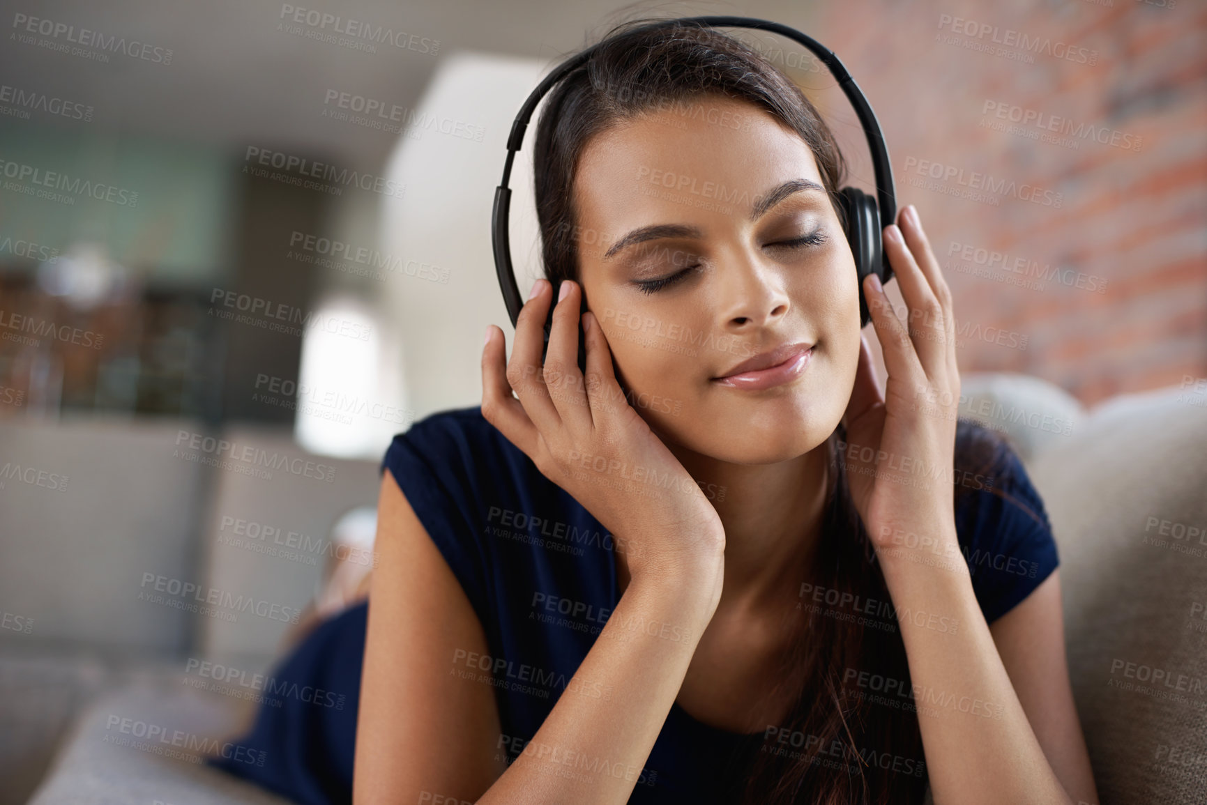 Buy stock photo Face, music and relax with woman on sofa in living room of home to smile for free time break. Headphones, peace and radio with young person lying on couch in apartment for weekend chilling or rest