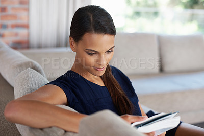 Buy stock photo Reading, book and woman relax on sofa in home on holiday or vacation with literature or creative story. Girl, study and enjoy novel with fantasy or journal on couch in apartment on calm weekend