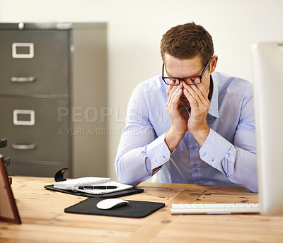 Buy stock photo Shot of a businessman sitting with his face in his hands