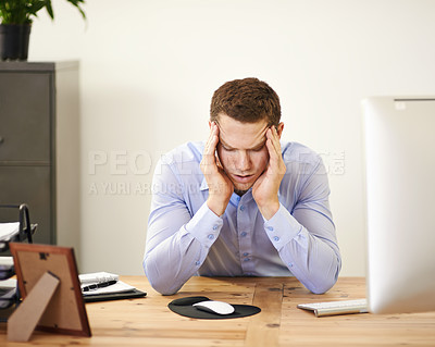 Buy stock photo An overwhelmed businessman sitting at his desk with his head in his hands