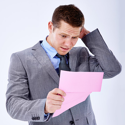 Buy stock photo Stressed, businessman and termination letter for work professional, formal and reading in white background. Male person, salesman and disappointed with job paper, fired and unemployment in studio