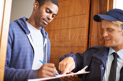 Buy stock photo Shot of a handsome young man signing a form for a courier