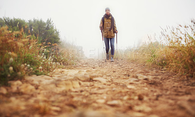Buy stock photo Low-angle view of a female hiker walking along a hiking trail