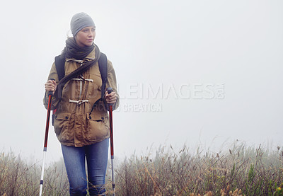 Buy stock photo Woman, hiking and nature with trekking sticks, winter and support for fog trail in mountain. Athlete, backpack and mountaineering gear for safety in wet environment, slippery and walking for fitness