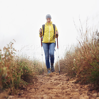 Buy stock photo Hiking, woman and walking with trekking pole in a bush path or forest trail for exercise, workout or fitness on winter morning. Adventure, person or hiker in nature with backpack on holiday or travel