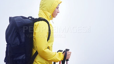 Buy stock photo Side view of a young woman standing in her hiking gear on an overcast day