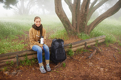 Buy stock photo Portrait of a young female hiker sitting by a tree on a hiking trail