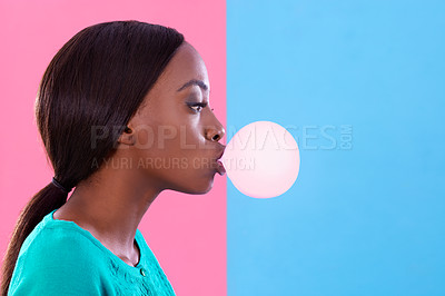 Buy stock photo Studio shot of an attractive young woman blowing a gum bubble against a colorful background