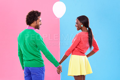 Buy stock photo Happy, couple and holding hands with balloon in studio for gender reveal on pink and blue background with fashion. Back, woman and man excited together with support in pregnancy, news or announcement