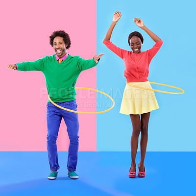 Buy stock photo Couple of friends, smile and play for dance, hoop and hand up for joy on color block background. Excited, man and woman for bonding, spinning and plastic toy for funky, quirky and game in studio