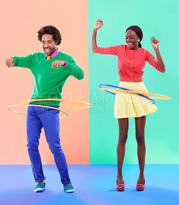Buy stock photo Couple of friends, laugh and play for dance, hoop and competition on color block background. Excited, man and woman for bonding, spinning and plastic toy for funky, quirky and game in studio