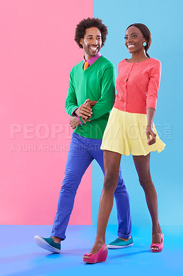 Buy stock photo Couple, walk and happy with fashion in studio, background and creative aesthetic. Excited, woman and man together with colorful retro style, unique clothes or person with support, love and trust