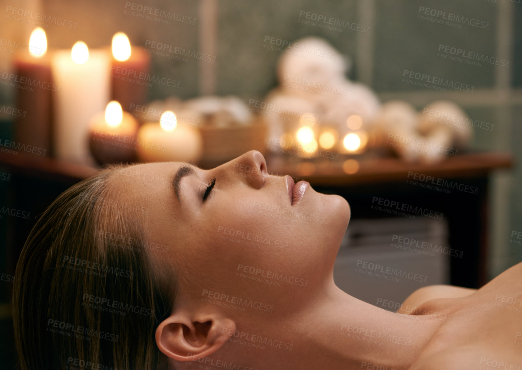 Buy stock photo A young woman lying with her eyes closed on a massage bed