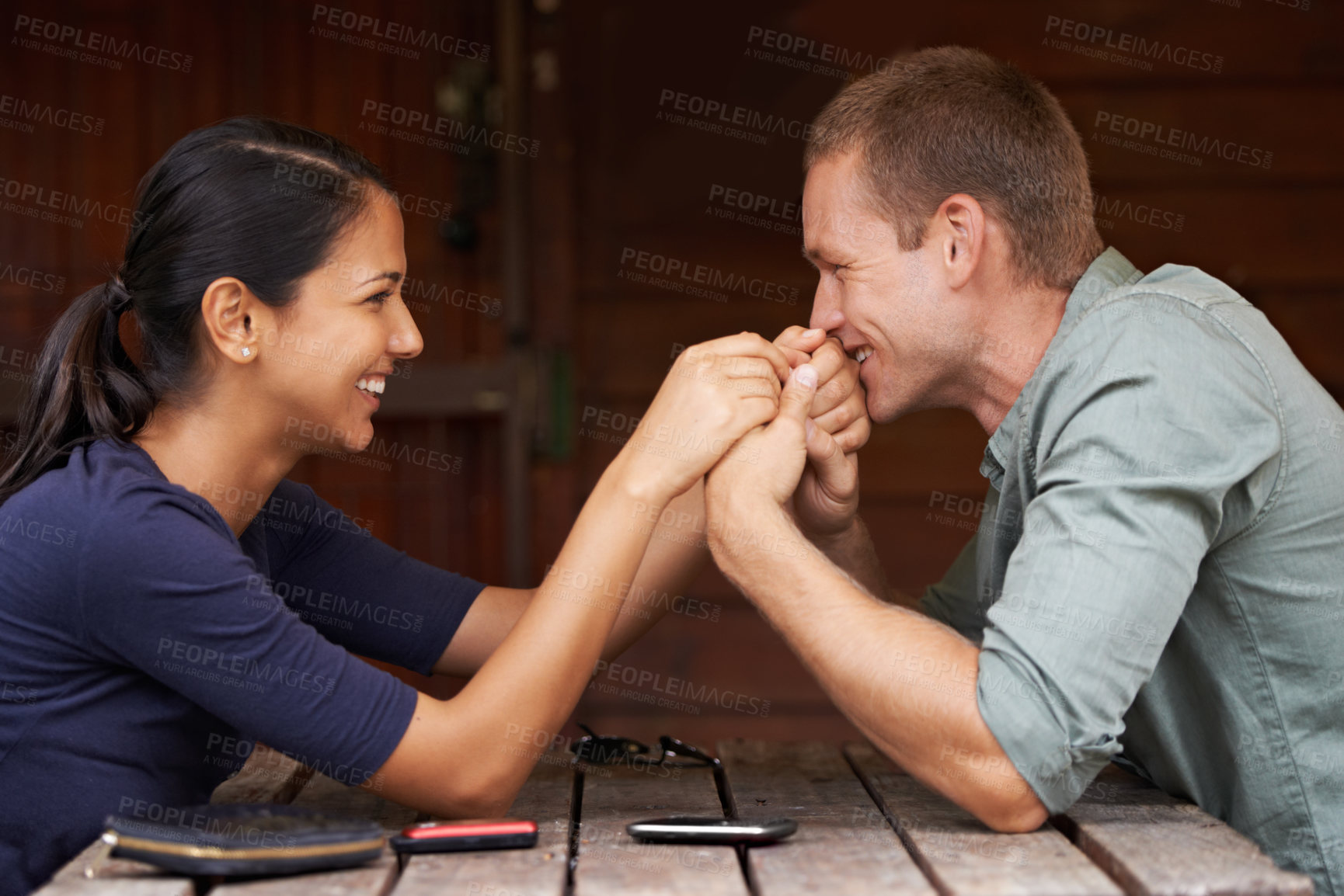 Buy stock photo A cute multi-racial couple sitting together and holding hands outdoors