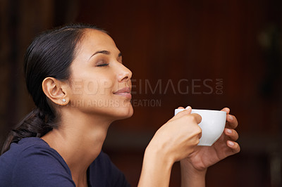 Buy stock photo A young woman drinking a cup of coffee outside