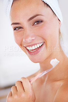Buy stock photo A gorgeous woman holding a toothbrush and flashing a perfect smile
