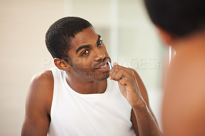Buy stock photo A young man brushing his teeth